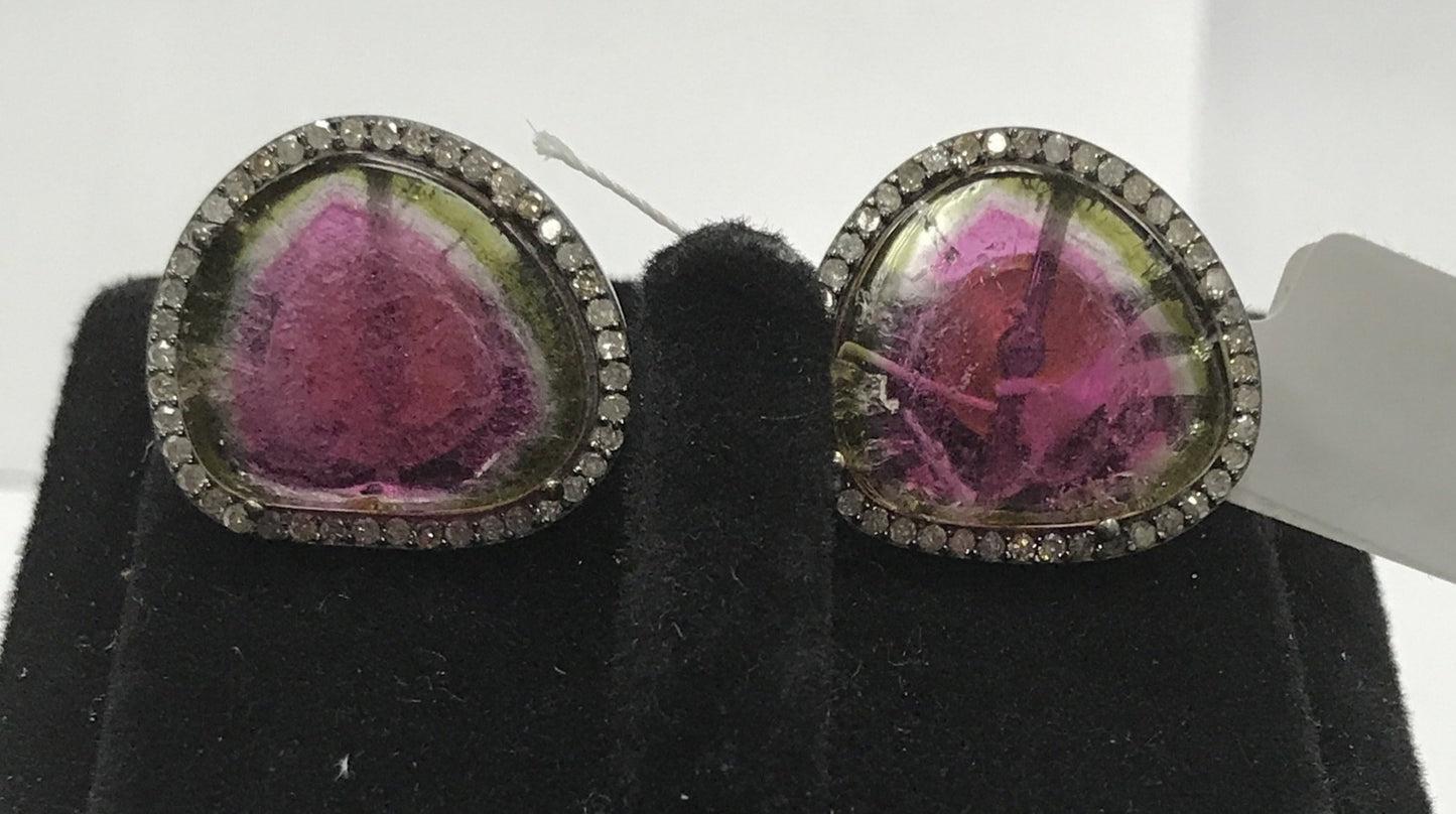 A pair of tourmaline watermelon and diamond earrings, with a gold and silver color scheme, displayed on a black mannequin.